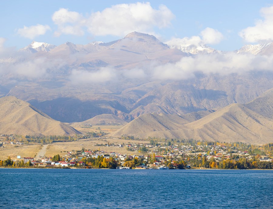 Natural Issyk Kul Lakeside And Town View In Kyrgzstan With Tian Shan Mountain Range