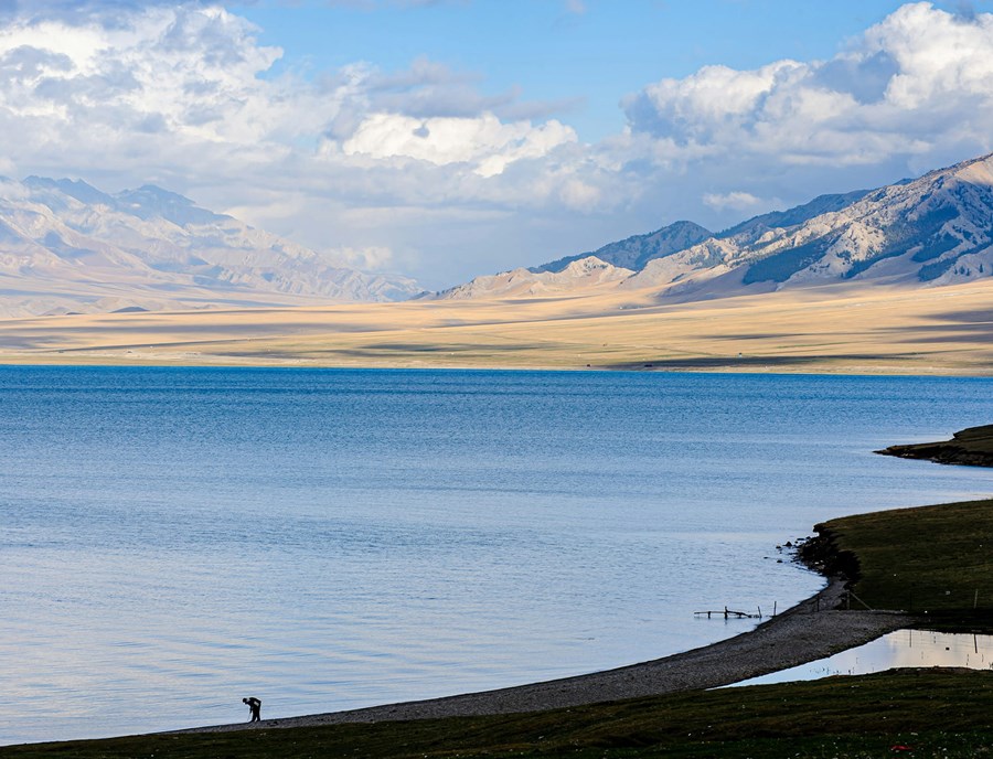 Take In The Brilliant Blue Waters Of Sayram Lake, Surrounded By The Mountains And Grasslands Of Xinjiang