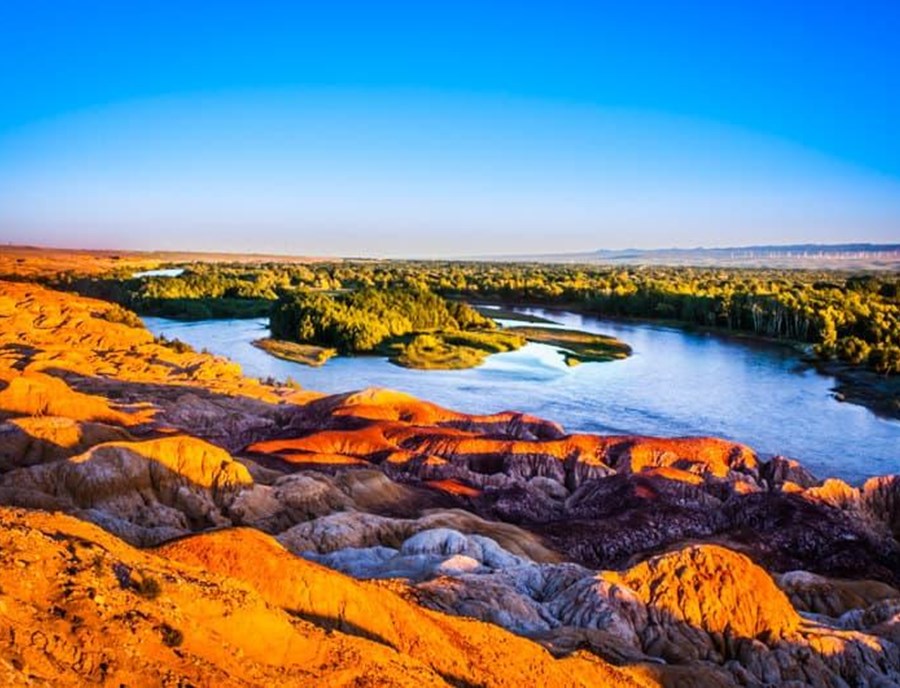 See The Colourful Rock Formations Of Wucai Beach Glow Against The Landscape Of Xinjiang