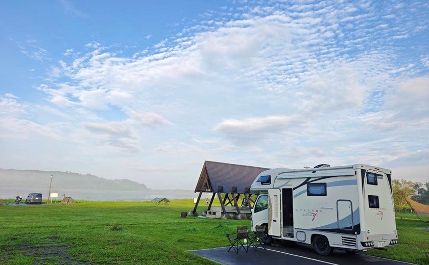 Camping by the lake with a Japan campervan under clear skies