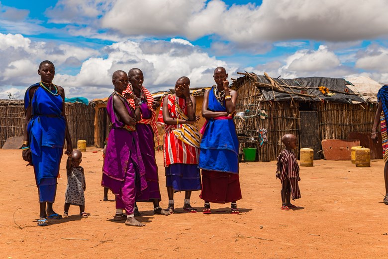 Maasai women in traditional dress communicate with each other in Kenya