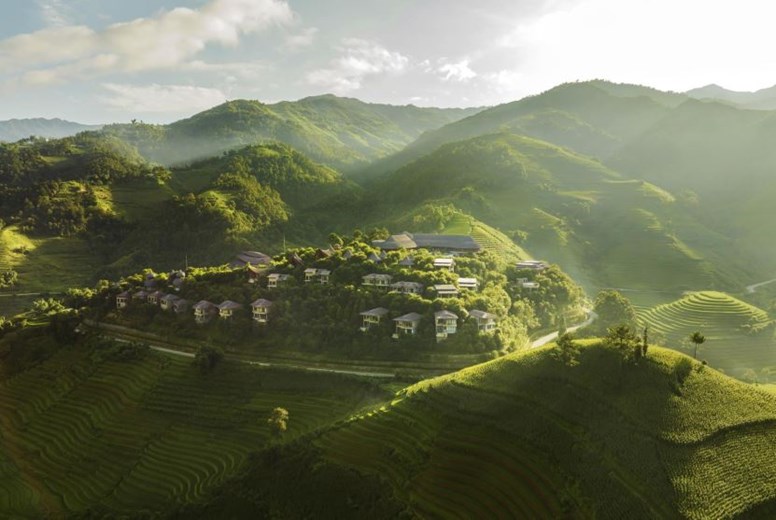 Aerial view of Garrya Mu Cang Chai Resort surrounded by lush rice terraces in northern Vietnam.