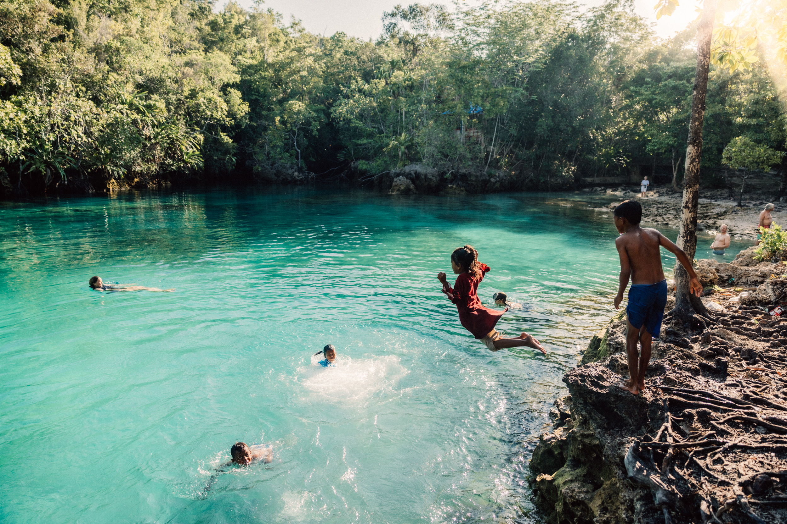 Kids swimming and enjoying Pulau Koon’s coral waters, a highlight of the Spice Islands.