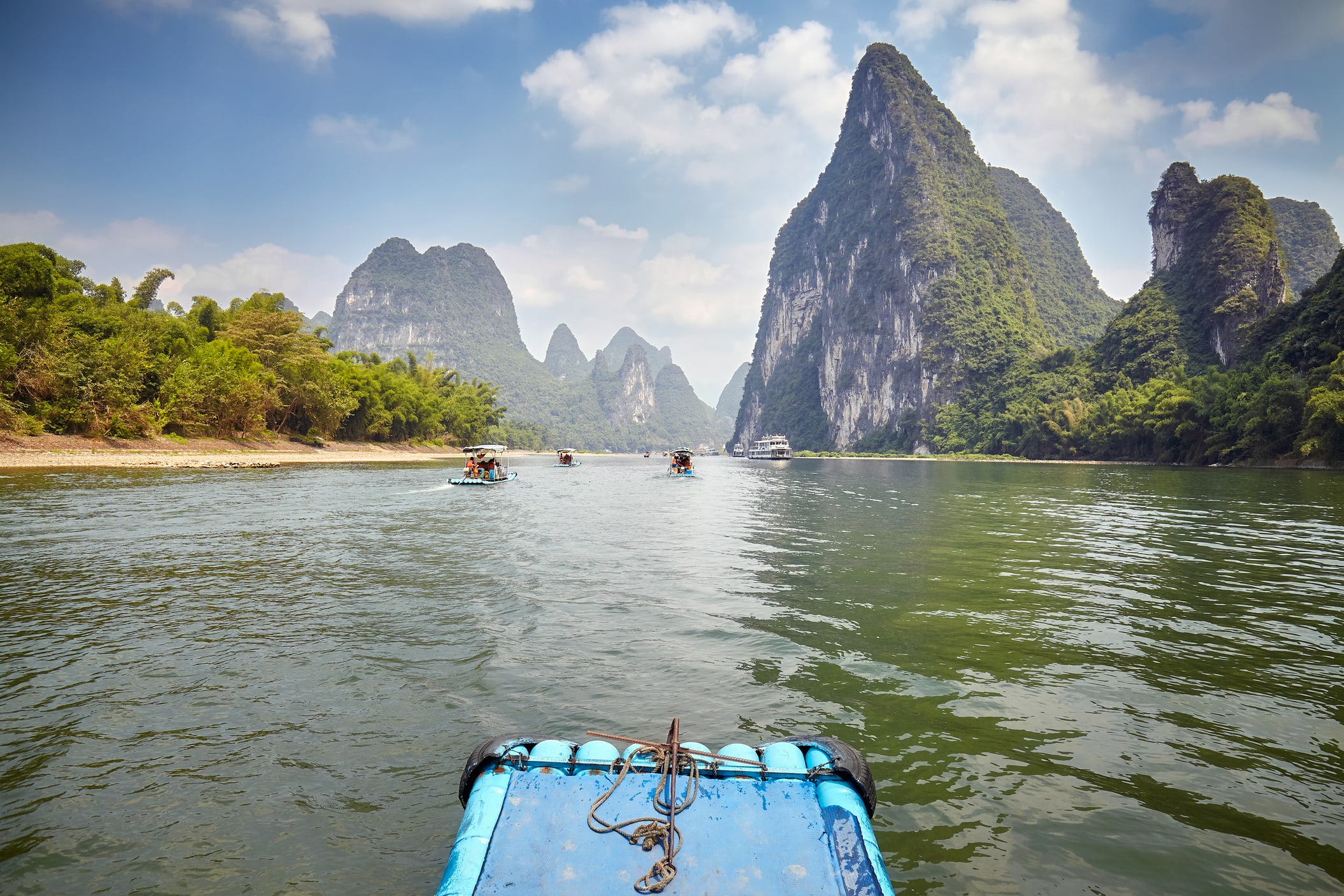 Cruise between dramatic karst peaks along the peaceful Li River