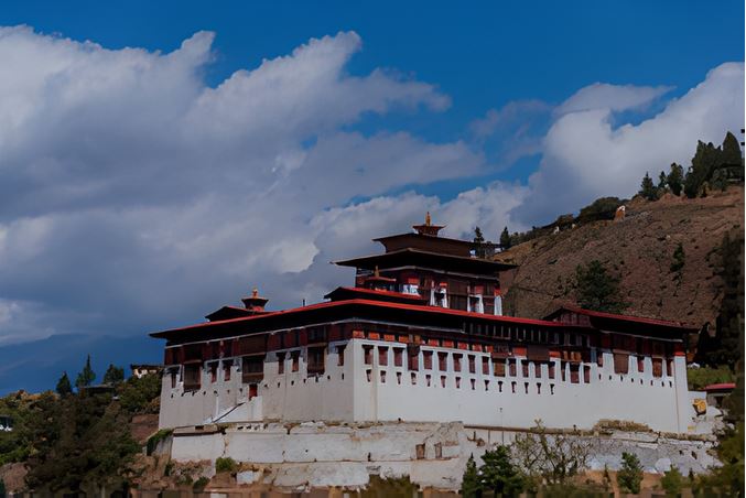 Rinpung Dzong (Paro Dzong) in Bhutan, a majestic fortress-monastery overlooking the Paro River and valley, featuring whitewashed walls, red and gold roofs, and traditional Bhutanese architecture against a mountain backdrop.