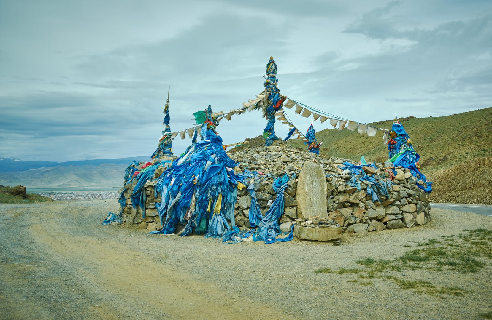 Sacred Ovoo Overlooking Vast Landscapes Along A Mongolian Mountain Pass