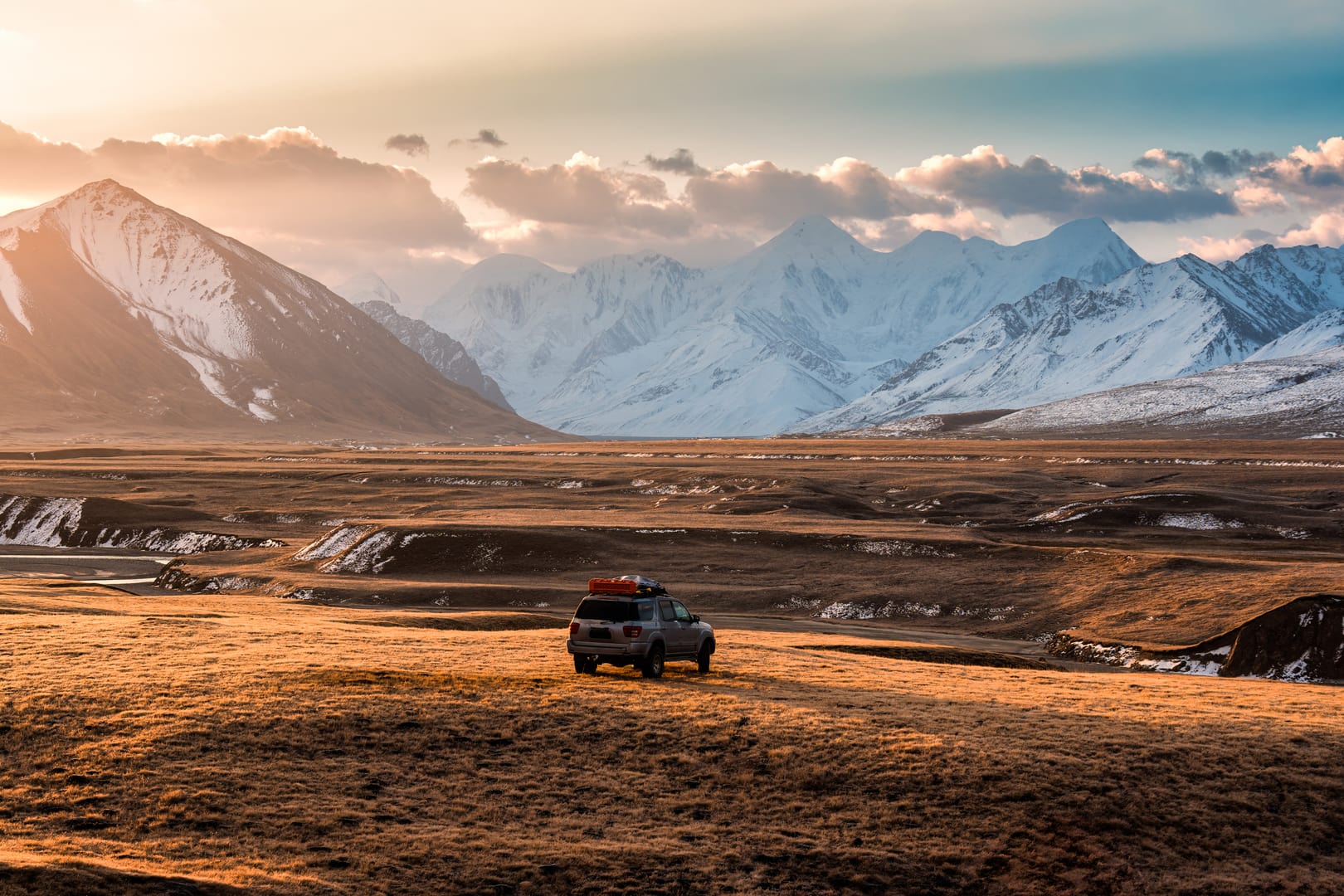 Off Road Adventure Crossing Mongolia Beneath A Golden Mountain Sunset