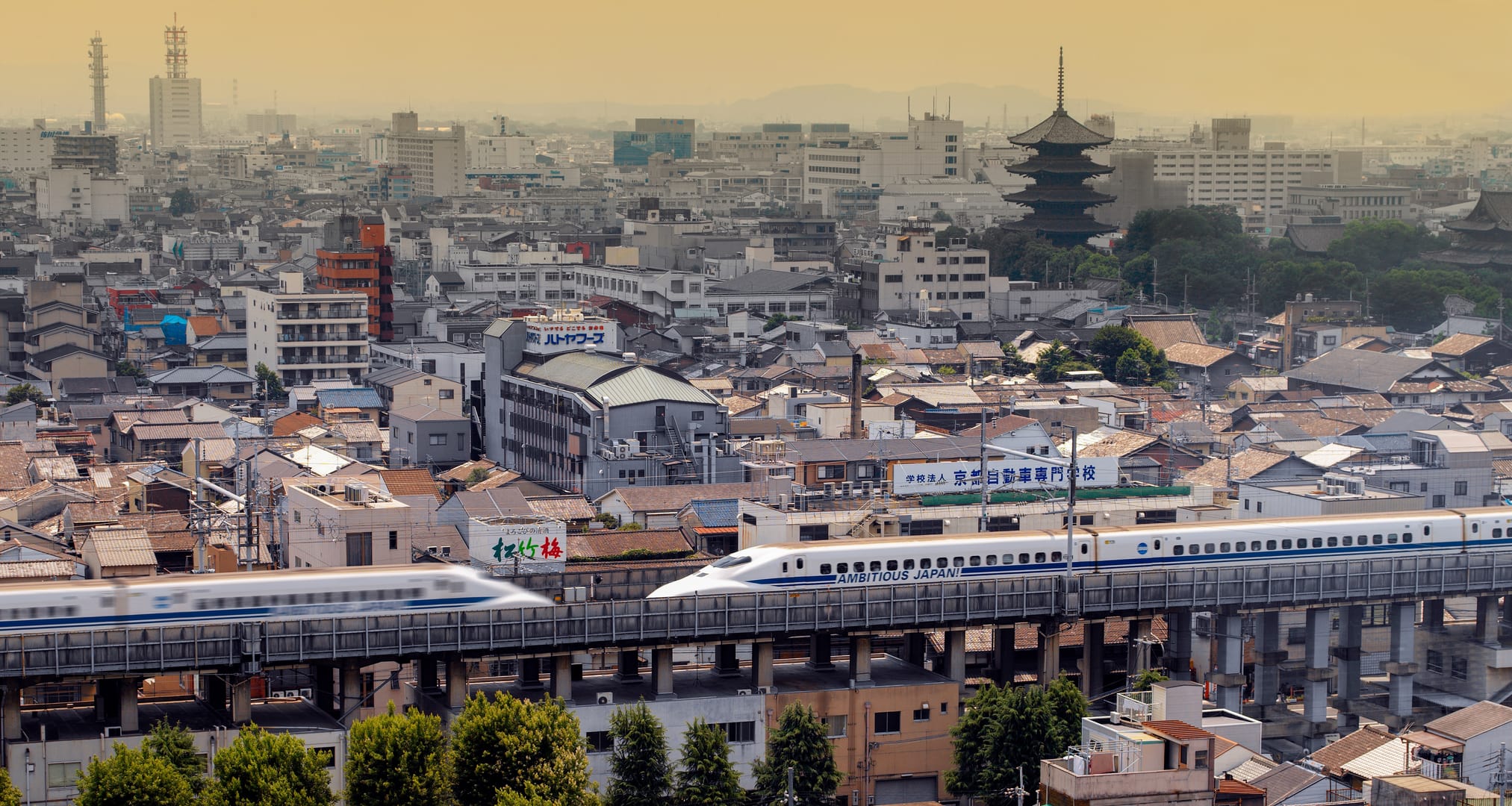 Shinkansen Gliding Through Kyoto With Traditional City Buildings In View